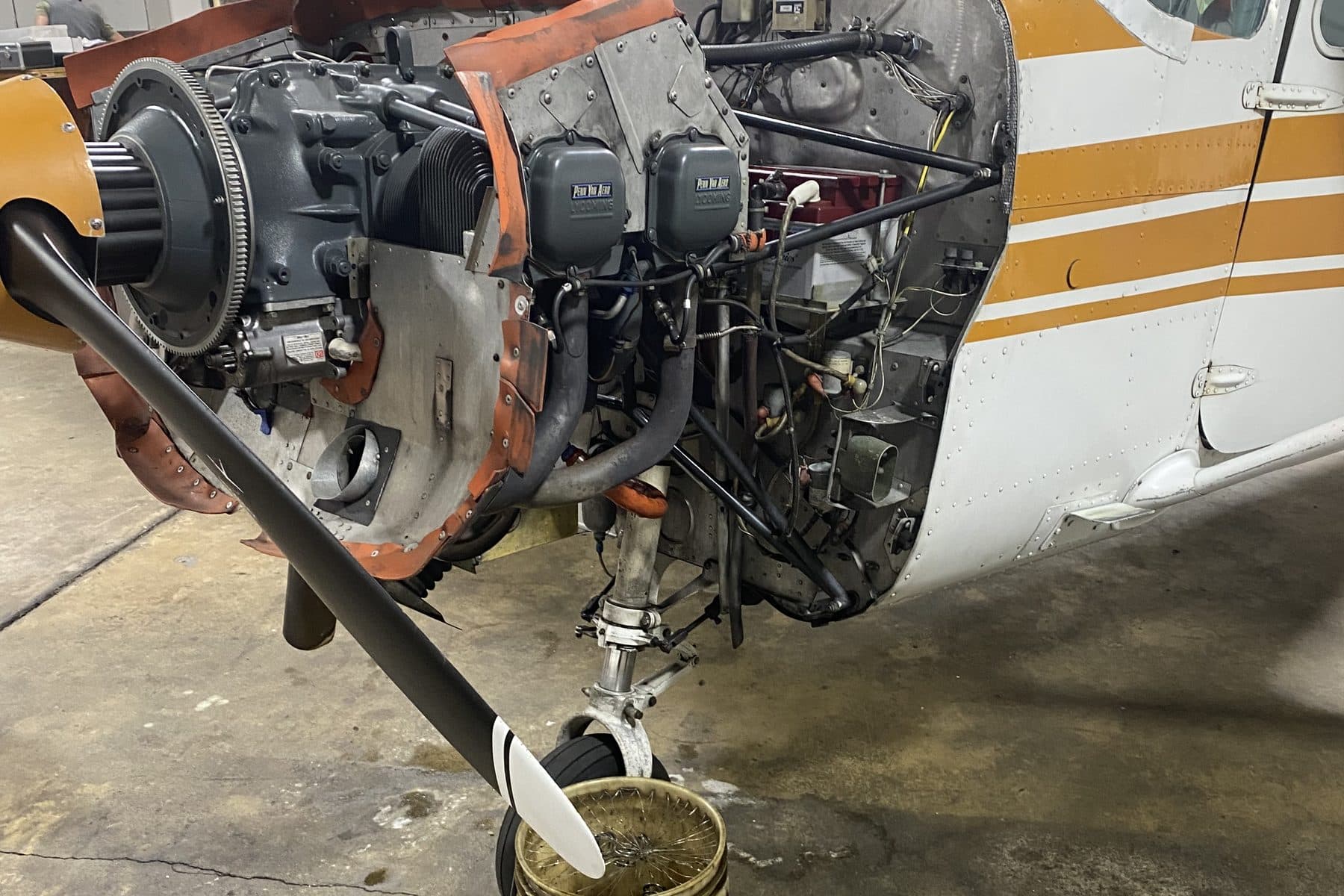 A Citizen Air Cessna 172 in the hangar with its cowling off and engine open for inspection